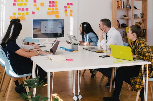 Team working together at a table looking at a screen